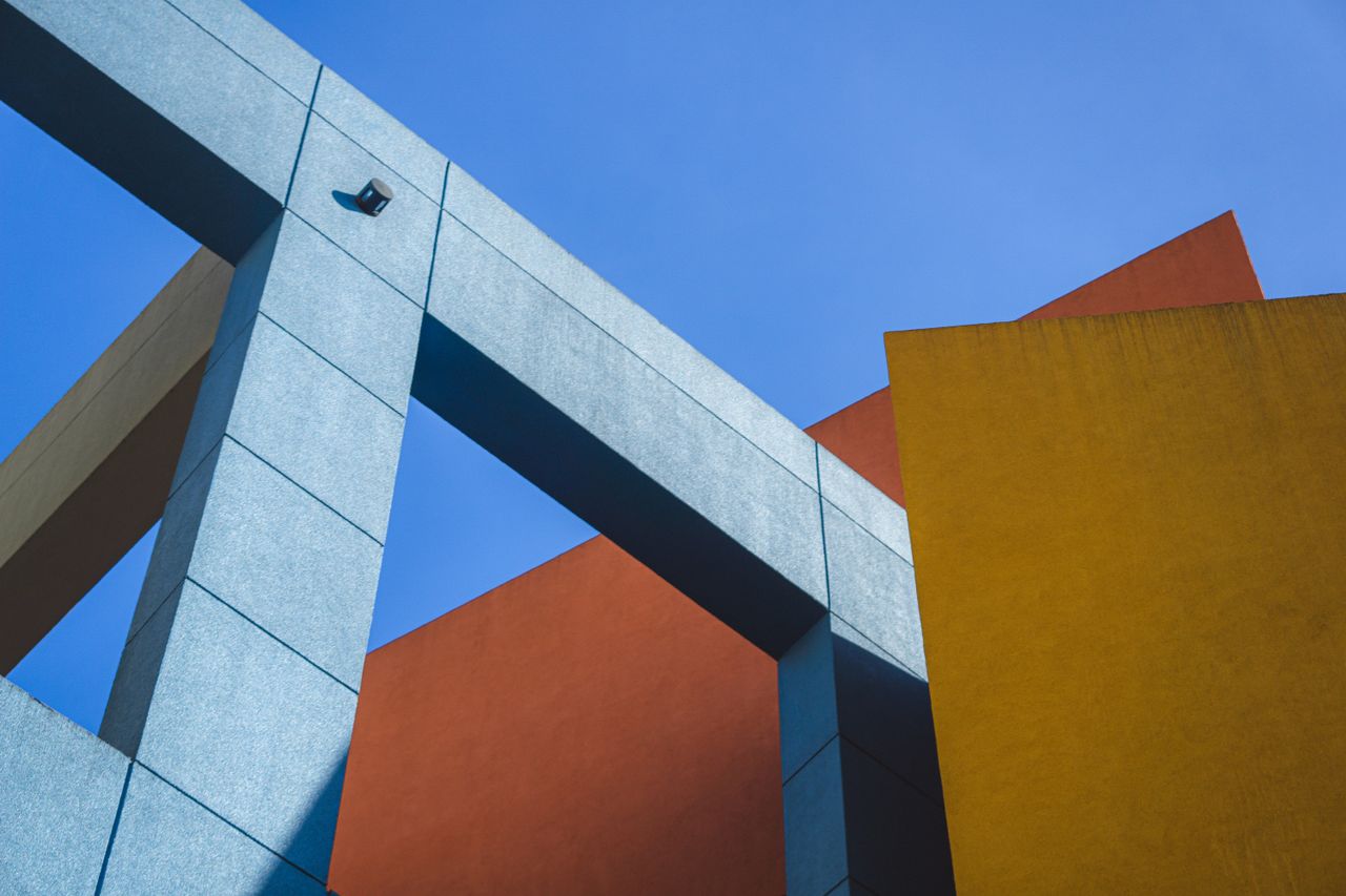 Dynamic shot of colorful geometric architecture against clear blue sky.